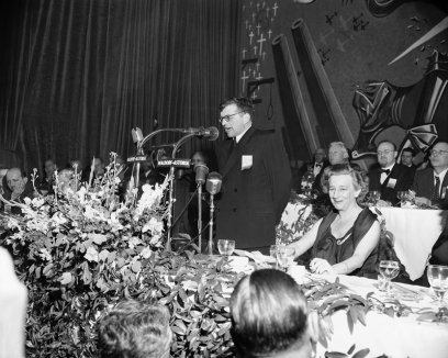 Russian Composer Dmitri Shostakovich addresses the Cultural and Scientific conference for World Peace at the Waldorf-Astoria in New York on March 25, 1949. In background is a huge painting with cannon, crosses, gallows and planes.    At right is Lillian Hellman, a playwright, and in right background (grey hair) is A.A. Fadeyev, secretary general of the union. (AP Photo/ Marty Lederhandler)
